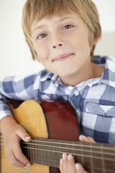 Young boy playing acoustic guitar
