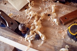 Close Up Of Wood Shavings And Carpentry Tools On Workbench