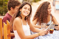 Teenage Friends Sitting At CafÃ?Â¢?? Using Digital Devices