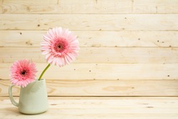 flower in cup with pine wood background.