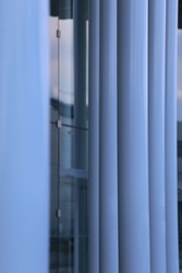 Close up graphic view of supperposed rows of white circular columns. Pattern of white and grey vertical parallel lines. Abstract view of part of a modern building. Architectural geometric view. 