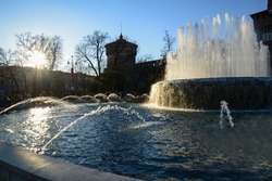 Fantastic view of Fountain next to  Sforzesco castle with sunbeams! Splashes of water in sun !  People in the distance