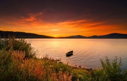 Lake boat at sunset. Boat in the lake at sunset