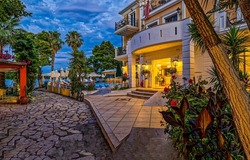 Entrance to the resort hotel by the sea in the evening. Resort hotel with swimming pool. Resort hotel entrance. Resort hotel in evening