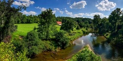 Summer panorama of the river among the greenery. River in summer. Summer river panoramic landscape. River on summer rural panorama