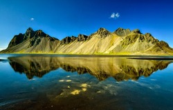 Mountain hills are reflected in the water of the lake. Lake water in mountains. Mountain lake view. Lake in mountains