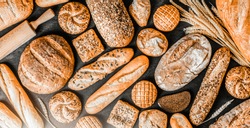 Fresh fragrant breads on the table. Bakery food concept panorama or wide banner photo.
