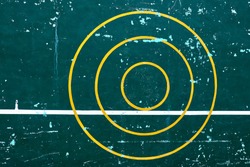 Three yellow concentric circle on the spotted green cement wall with another white level line is tangent with the smallest circle. The concept for target, practice, concentration.