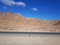 Picturesque Jordanian roadside with dry hills and blue sky