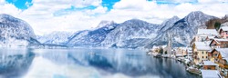 Panorama view of Hallstattersee lake and mountain in daylight with snow. Landscape view of famous Hallstatt lakeside town during winter. Town square in Hallstat. Salzkammergut region, Austria. Europe