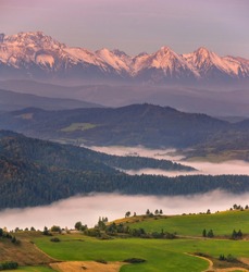 Autumn morning with fog in the valleys and softly lit mountain peaks. Pieniny and Tatras in Slovakia. Holidays in Slovakia.