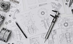 Engineer technician designing drawings mechanical parts engineering Engine
manufacturing factory Industry Industrial work project blueprints measuring bearings caliper tool.