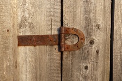 Old rusty metal door hinge. Door hinge on a wooden wall.