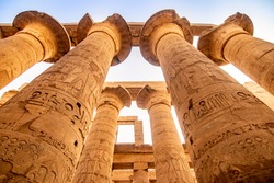 EXPLORING EGYPT - KARNAK TEMPLE - Massive columns inside beautiful Egyptian landmark with hieroglyphics, and ancient symbols. Famous landmark in the world near the Nile River and Luxor, Egypt
