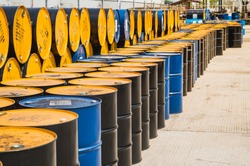 Industry oil barrels or chemical drums stacked up.container of  barrels of hydrocarbons.hazardous waste of black and blue tank oil.Stack Of Oil barrels in plant.