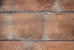 underside of old wooden pine floorboards, mid brown colour with cracks and signs of age, detail photo