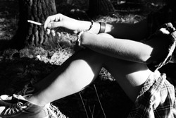 Black and white photo of a woman holding a cigarette/smoking sitting down in a forest/trees
Lost in the woods, stressed,anxiety