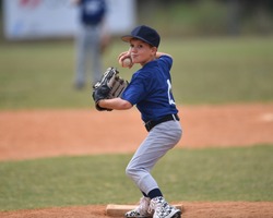 Young boy pitching the ball in a baseball game