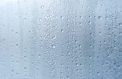 Condensation drops on window glass, natural blur abstract background.