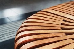 Modern curved wooden bench at the airport. Modern interior close-up