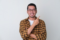 Adult Asian man pointing finger to the left with smiling face
