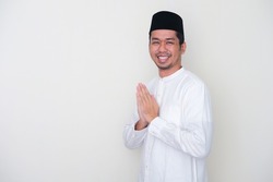 Side view of Moslem Asian man smiling to give greeting during Ramadan celebration