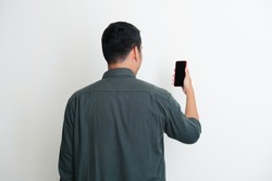 Back view of a man looking to the mobile phone that he hold