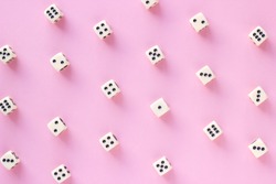 Gaming dice pattern on pink background in flat lay style. Concept for games, game board, presentation, banners or web. Top view. Close-up.
