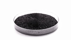 graphite powder used in industry, black powder with isolated white background and copy space.