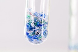 close-up of test tube with traces of plastic and micro plastic taken from the ocean, polymer particles, pollutant from the seas, environmental problem