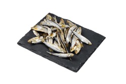 Small dried fish on black slate board isolated on white background