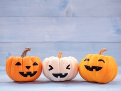 Orange and white pumpkins halloween decorate on blue wooden background. Use for halloween concept.
