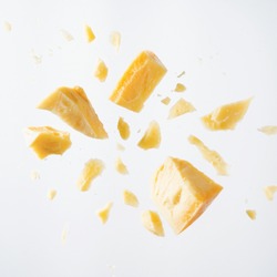 Parmesan cheese flying in different directions with crumbs on a white background with space for the text. 