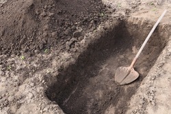 Digging a pit. Pit in the ground. The shovel  in the pit.
