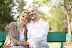 Portrait of happy elderly couple hug together, take care and love with good relationship, good health and romantic in the park, retirement insurance and lovely couple concept