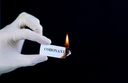 Paper with the text Coronavirus is burning in the hand. The concept of defeating the Coronavirus.