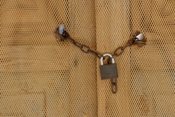 Chain and lock on a door covered with net
