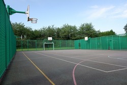 Multi-use sports court with basketball nets and football goals