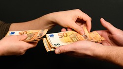 People count money, counting euro bills by man and woman, money on black background. new