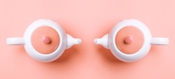 Banner. Two white porcelain teapots with a pink lid on a pink background. Flat lay. Copy space. Concept of female health and Breast Cancer Awareness Month.