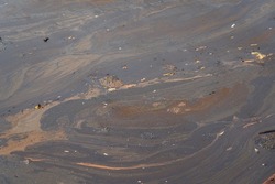 Crude oil or chemical is contaminated with natural water due to oil leaking accident. Environmental impact from industrial process photo scene.