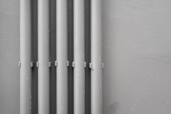Water transfer PVC pipelines in vertical on the building wall, photo in gray scale color. 