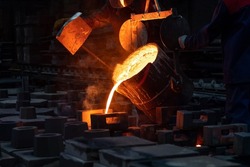 The liquid metal or cast iron poured into molds. Metal casting process with red high temperature fire in metallurgical factory. Metal part factory, foundry cast, heavy industry