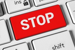 Stop word on the button of the white computer keyboard. The concept of stopping work, playing, war, procrastination, ending podcast, streaming