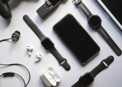 Flat lay shot of gadgets and mobile devices in white background. 