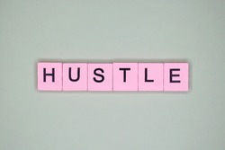 Hustle word wooden cubes on a light background