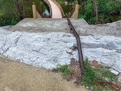 Stair-safe bike ramp along stairs. Comfortable and safe lanes for bicycles on stairs. Old and rusted steel rails for bicycles up and down for comfort between steps on stairs in the public park.