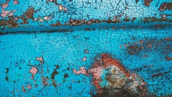Enamelled colorful cracked and peeling surface of old motorcycle. Rusty metal surface with blue cracked paint. Old motorbike paint cracks and rust. Rusty old metal. Vintage textured background concept