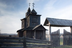 old abandoned wooden church in the countryside. church yard with wooden fence and old gate.