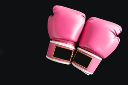 pink boxing gloves for girl and woman fight with copy space in dark background.